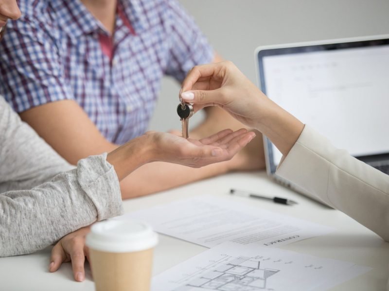 buying-new-house-concept-realtor-giving-keys-couple-closeup-scaled.jpg