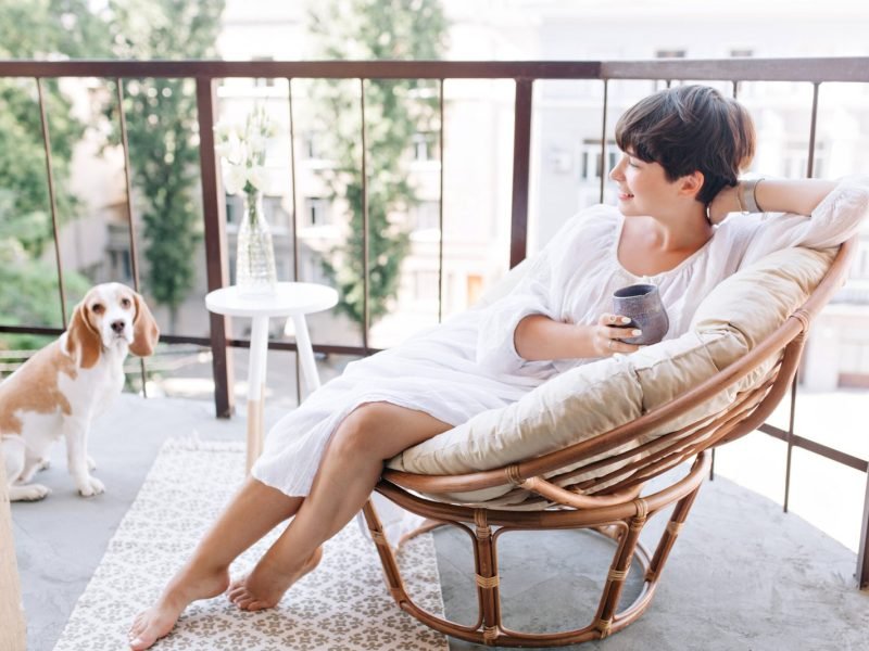 relaxed-barefooted-girl-white-dress-sitting-chair-balcony-holding-cup-tea-scaled.jpg